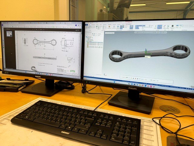 CAD-Arbeitsplatz mit technischer Zeichnung und 3D-Modell